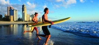 Deux hommes qui s'élancent dans l'eau avec une planche de surf