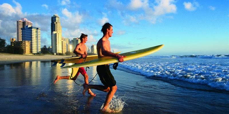 Deux hommes qui s'élancent dans l'eau avec une planche de surf