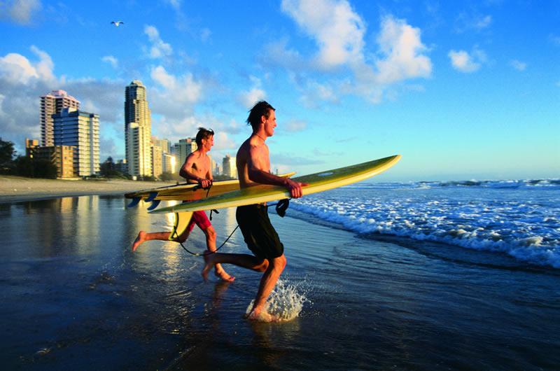 Deux hommes qui s'élancent dans l'eau avec une planche de surf