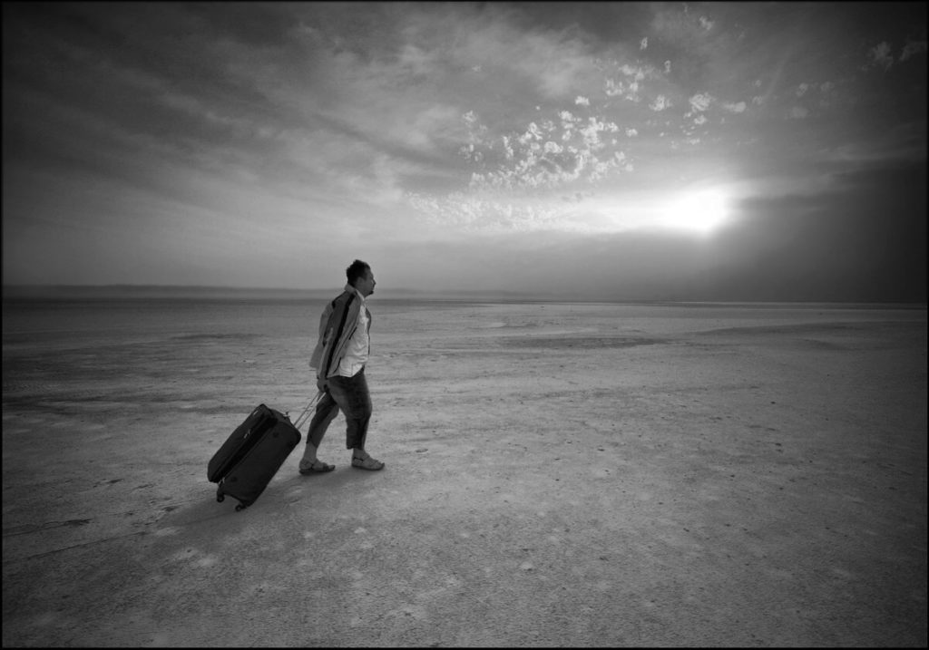 Un homme seul marche en tirant une valise